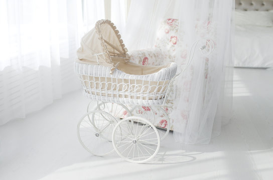 white stroller for a baby in a white classic interior