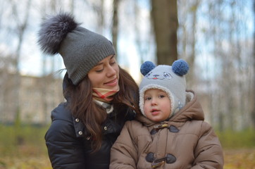 young mother and son on a walk in the cold autumn outdoors. happy family, love and life