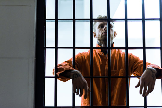 prisoner putting hands between prison bars
