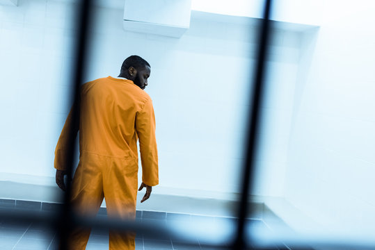 back view of african american prisoner in prison cell