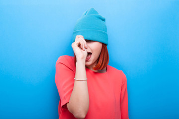 Cool hipster girl wearing a blue hat on blue background