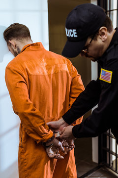 prison guard wearing handcuffs on prisoner
