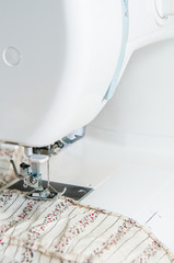 Modern Sewing machine with light flower pattern fabric.