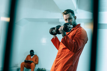 prisoner training with dumbbells in prison room