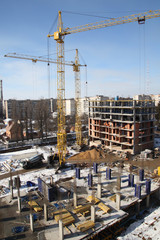 Working crane on the construction of the house. Construction site with cranes on sky background. 