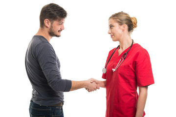 Male patient and female doctor shaking hands.
