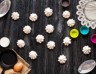Sweet white meringue and other components on a wooden background, free space for text.