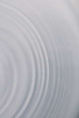circular wave motion in a fluid system. blue gray background for a liquid pushed into a circular...