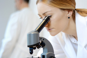 Arzt oder Wissenschaftler bei Untersuchung und Auswertung mit Mikroskop
