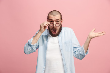 Beautiful man looking suprised isolated on pink