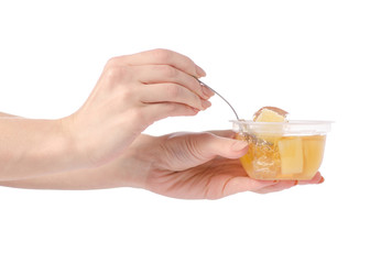 Cup of jelly with fruit yellow pineapple in hand isolation