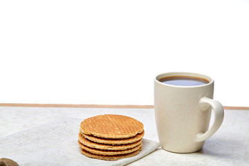 Close-up white cup of coffee with waffles on white background, top view