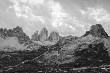 Die berühmten Drei Zinnen in den Sextener Dolomiten in Schwarz-Weiß mit einer Berghuette,...
