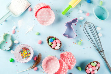 Sweet baking concept for Easter,  cooking background with baking - with a rolling pin, whisk for whipping, cookie cutters, sugar sprinkling, flour. Light blue background, top view copy space