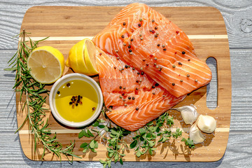 Close up ingredients for salmon filet with Italian herbs on bamboo tray