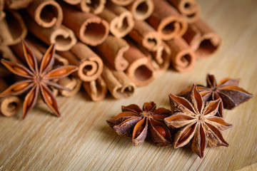  shelves of cinnamon and anise stars in dark backgrounds on a wooden background