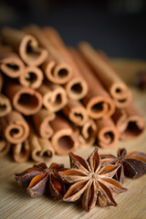  shelves of cinnamon and anise stars in dark backgrounds on a wooden background