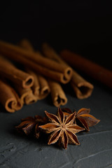  shelves of cinnamon and anise stars in dark colors on a dark concrete stone background