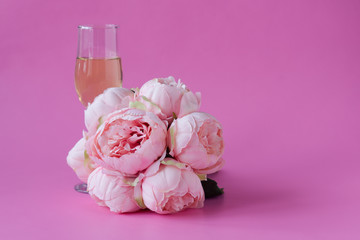 Glass of wine and .bouquet of peonies. Space for text