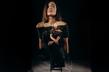 Double exposhure. Artistic portrait of a young beautiful woman. Fashion theater of fashionable girl in dark dress on big black background. Studio. Low Key. Fashion. Beauty.