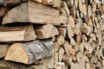  A lot of dry chopped firewood is stacked in the period of preparation for the furnace chopped logs for winter fire