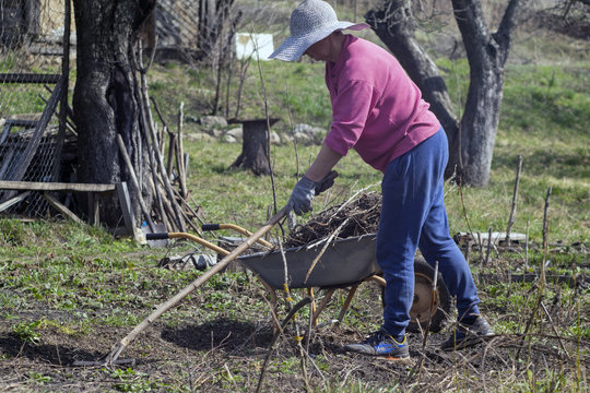 Woman working with a rake in a spring garden