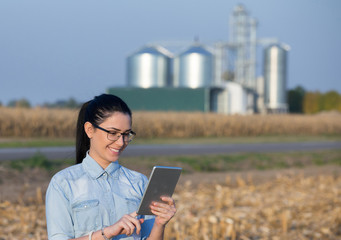 Farmer woman with tablet and silos