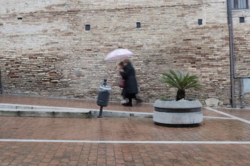 Fototapeta na wymiar blurry people walking in town with rain