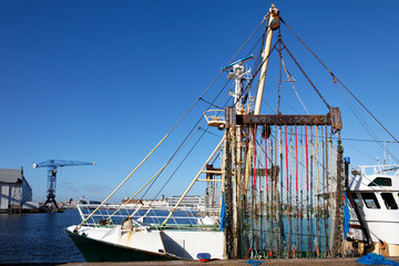 Fototapeta na wymiar Colorful pulse trawl on a pulse trawls vessel in the harbour with a blue sky