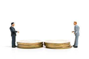 Miniature people: Businessman standing on stack of coin