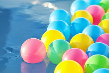 Multicolored plastic balls float in the children's pool