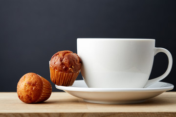 Cup of tea with cookies, workbook and a pencil on a wooden background, top view