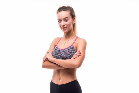 Photo of cheerful young sports woman standing isolated over white background looking camera with arms crossed.