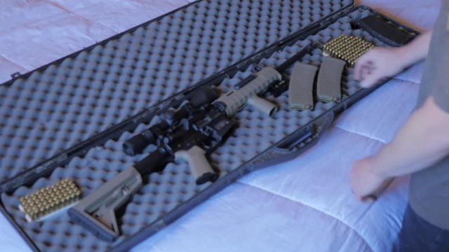 Gun case placed on a bed and opened. 