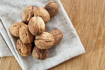 A stack of walnuts piled together and on rustic wooden background, shallow depth of field, selective focus