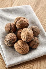 A stack of walnuts piled together and on rustic wooden background, shallow depth of field, selective focus