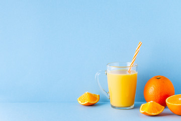 Orange juice on a blue pastel background