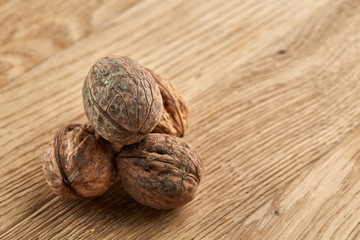 A stack of walnuts piled together and on rustic wooden background, shallow depth of field, selective focus