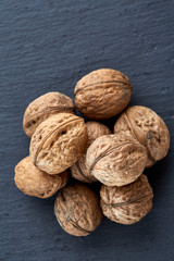 A stack of walnuts piled together and isolated on dark background, shallow depth of field, selective focus