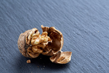Top view close-up shot of cracked walnuts on dark background, shallow depth of field, macro