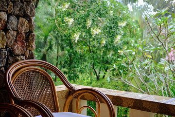 Wicker chair on balcony, cup of coffee and book. Concept calmness, meditation, old age, downshifting. Thailand