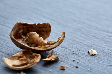 Top view close-up shot of cracked walnuts on dark background, shallow depth of field, macro