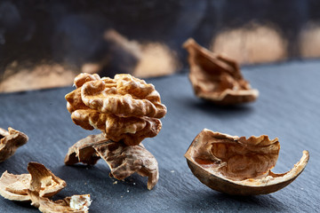 Top view close-up shot of cracked walnuts on dark background, shallow depth of field, macro