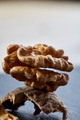 Top view close-up shot of cracked walnuts on dark background, shallow depth of field, macro