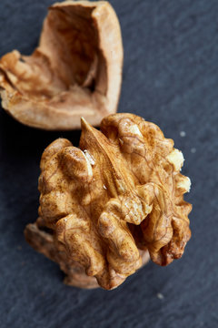 Top view close-up shot of cracked walnuts on dark background, shallow depth of field, macro