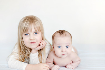 Portrait of brother and sister. Two cute children  lying on bed.  Brother and sister best friends, happy family and  childhood concept