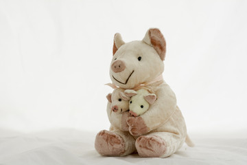 Piglet doll carrying baby on a white background