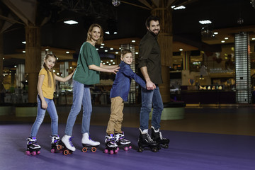 parents and kids skating together on roller rink