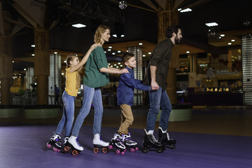 parents and kids skating together on roller rink