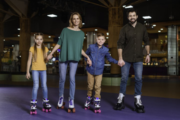 parents and kids skating together on roller rink